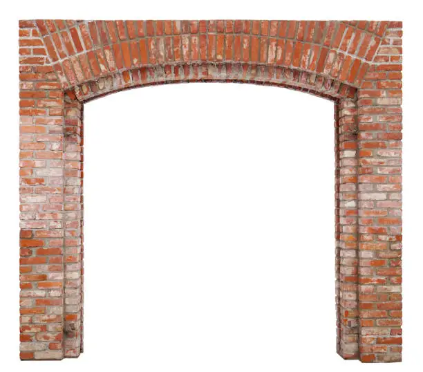 Photo of The arch for the gate of the village barn is made of red bricks. Isolated