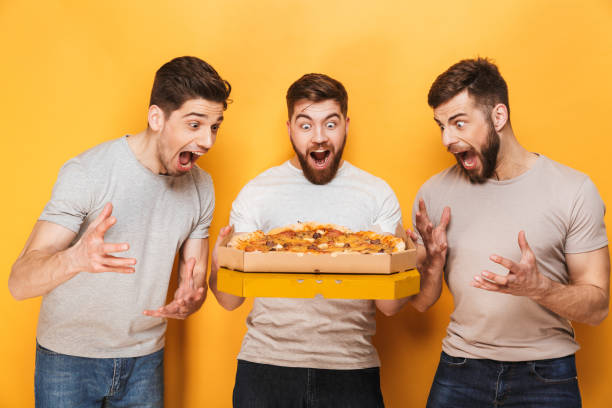 istock Three young excited men holding a big pizza 1307372992
