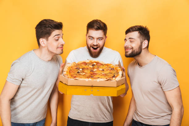 istock Three young happy men smelling a big pizza 1307373336