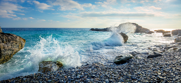 Coastal seascape scene with water rushing over rocks in dramatic light at sunrise
