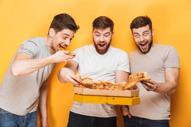 istock Three young cheerful men eating big pizza 1307374827