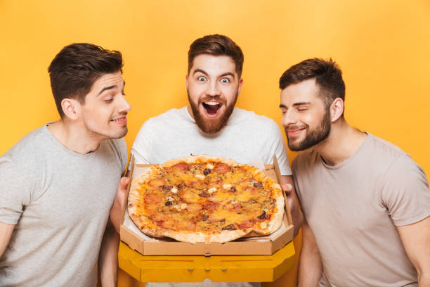 istock Three young smiling men smelling a big pizza 1307375527