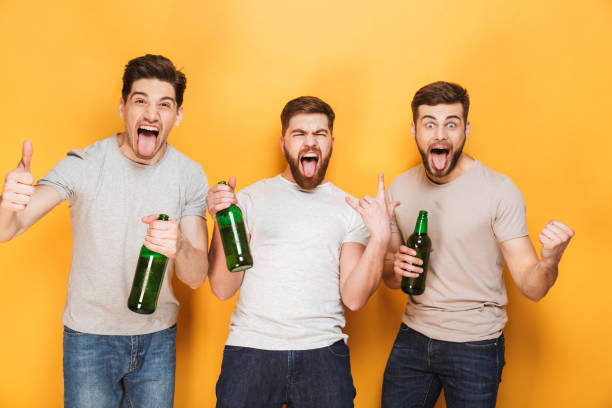 istock Three young men holding beer and celebrating 1307375561