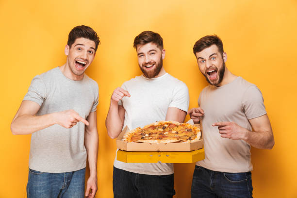 istock Three young happy men holding a big pizza 1307375600