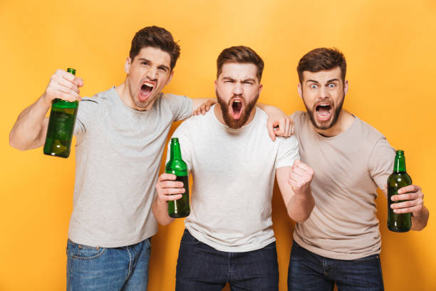 istock Three young joyful men holding beer and celebrating 1307376603