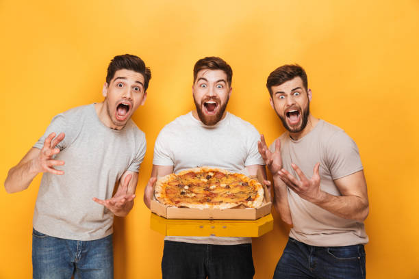 istock Three young cheerful men holding a big pizza 1307376661