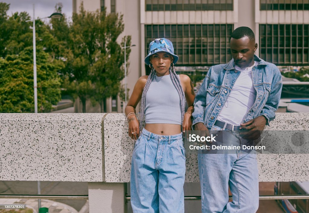 They call us fashion icons around here Shot of a trendy young couple leaning against a wall in the city Street Style Stock Photo