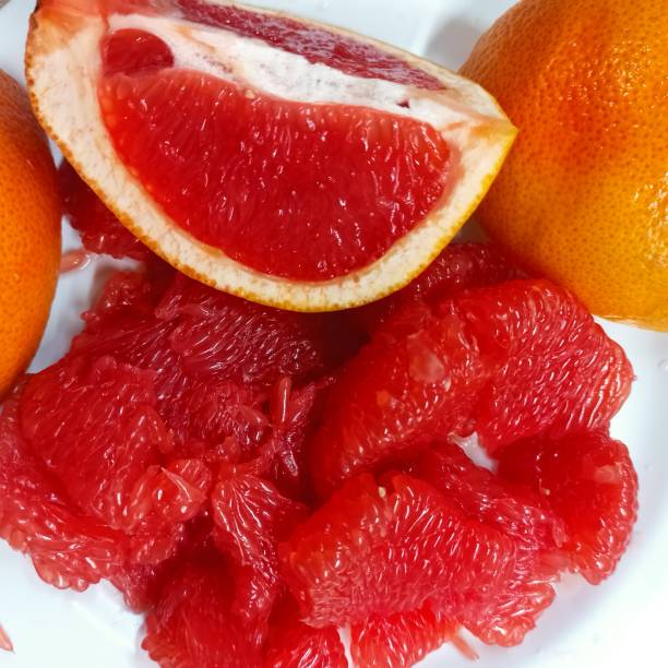 istock The grapefruit is juicy in a cut, slices and pulp on a white plate. View from above. 1307378859