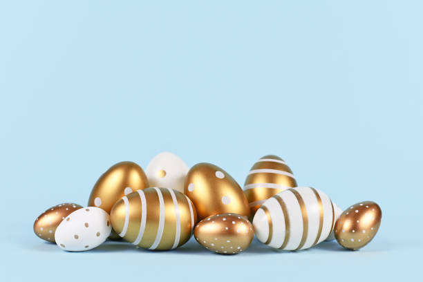 istock Elegant golden and white Easter eggs painted with simple dots and stripes on blue background 1307379677