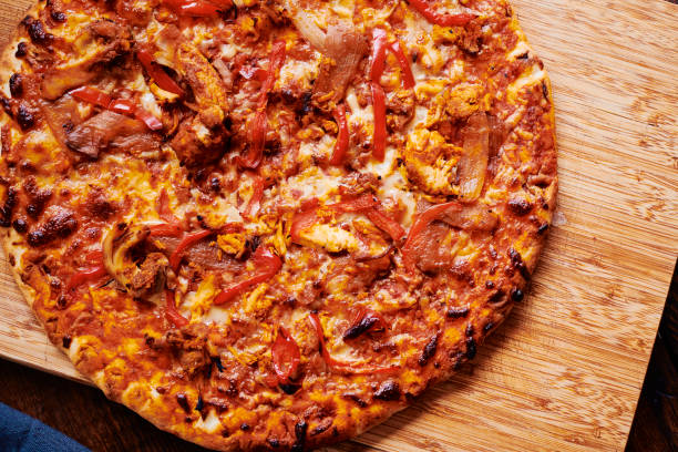 istock Overhead view of a spicy Chicken pizza on a chopping board. 1307379909