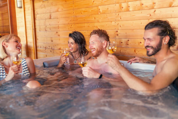 istock Friends drinking wine and relaxing in a hot tub while on a vacation 1307381154