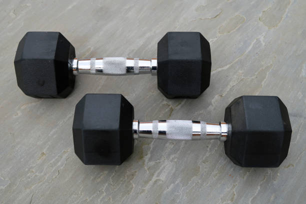 istock Pair of hexagonal dumbbells, outdoors on grey slate surface 1307381202