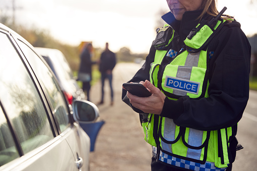 Oficial de policía de tránsito registrando detalles del accidente de tráfico en el teléfono móvil photo
