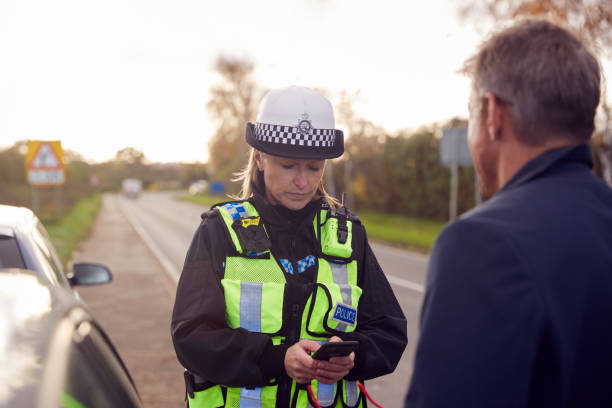 un agent de la police de la circulation prend la déclaration d’un témoin d’un conducteur lors d’un accident de la route sur un téléphone portable - police statement photos photos et images de collection