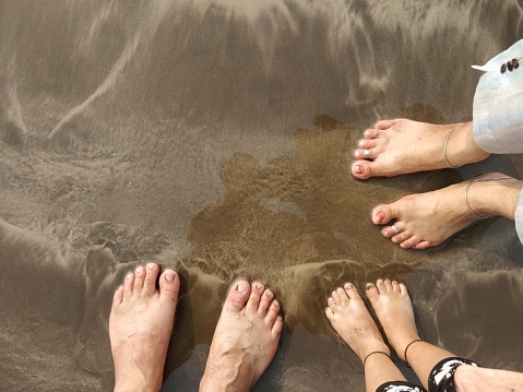 Low section of legs on shore at beach during vacation