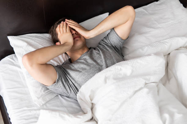 istock Young man trying to wake up in bed 1307386428