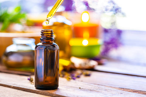 aromarherapy: botella de aceite esencial sobre mesa de madera - aromatic oil fotografías e imágenes de stock