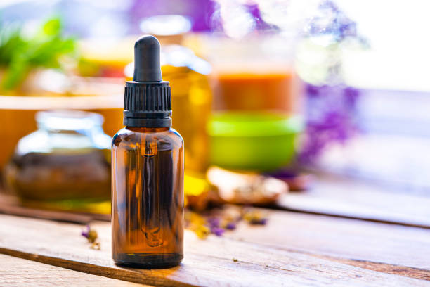 aromathérapie : bouteille d’huile essentielle sur table en bois. espace de copie - flacon huile essentielles table en bois photos et images de collection