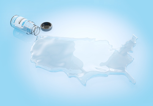 3D concept image of a coronavirus COVID-19 vaccine vial that has fallen over and spilled out the vaccine in the shape of the United States.