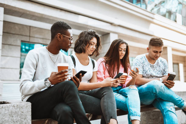 istock Antisocial Students Using Smartphones While Waiting For The Bus Together After University Lesson 1307392498
