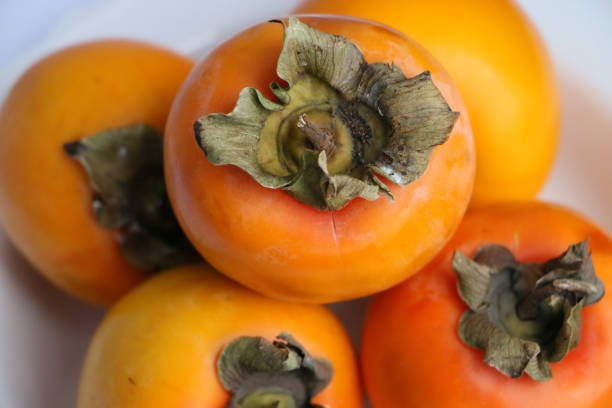 istock Fresh Ripe Persimmons on a White Classic Design Plate, Paradise Palms 1307392678