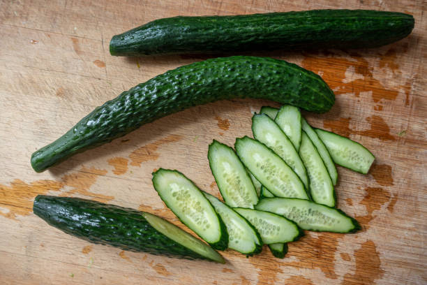 Sliced cucumber on wooden kitchen board