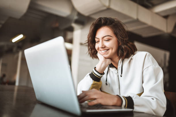 istock Cute Smiling Female Texting Friends On Laptop 1307392793