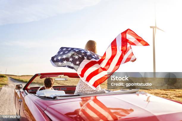 Woman Holding An American Flag On A Road Trip Stock Photo - Download Image Now - American Flag, Car, American Culture