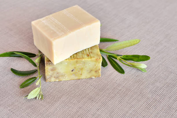 istock Handmade soap bars and olive branches on fabric background 1307394250