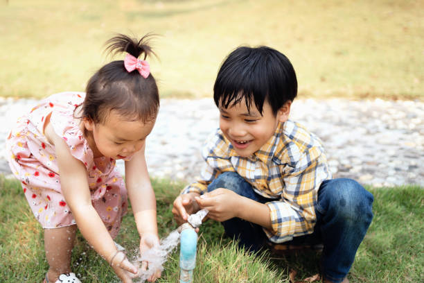 istock Two brothers and sisters play water from the tap 1307395934