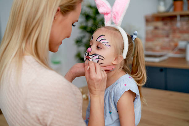 istock Face painting for little Easter bunny at home 1307396008