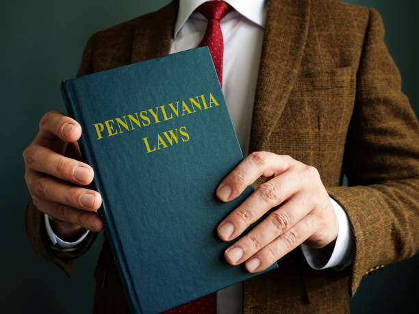 istock Man in suit holds Pennsylvania law code. 1307397175
