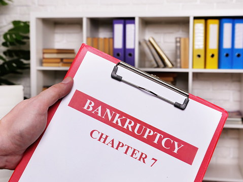 Bankruptcy chapter 7. The manager holds the sheets and clipboard.