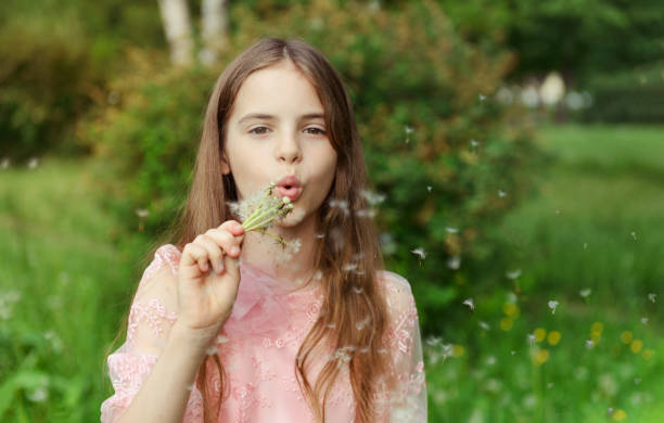 ragazza bianca 10 anni con denti di leone in natura in estate - 10 11 years cheerful happiness fun foto e immagini stock