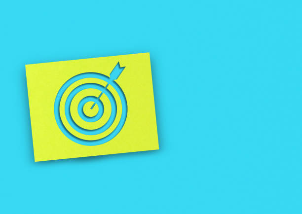 istock Yellow note paper and target sign with copy space on blue background 1307398464