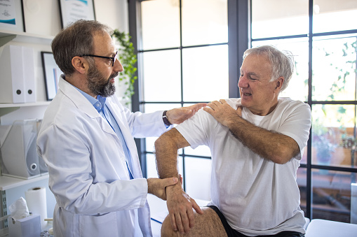Physical therapist checking where the pain starts on patient's arm
