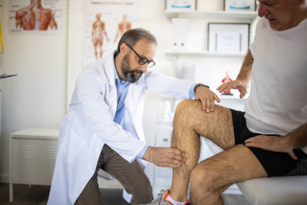 istock Physical therapists checking patient's knee at doctor's office 1307398778