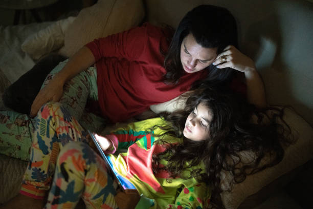 istock Mother and daughter in bed watching something on digital tablet 1307402994