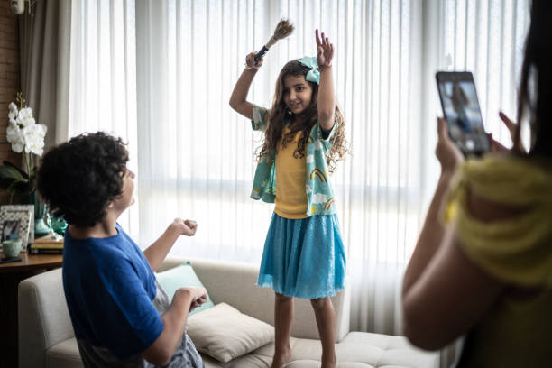 istock Siblings being filmed while playing and singing at home 1307403071