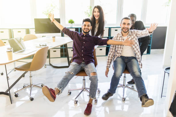 istock Multiethnics startup business team of software developers having fun while racing on office chairs,excited diverse employees laughing enjoying funny activity at work break 1307403824