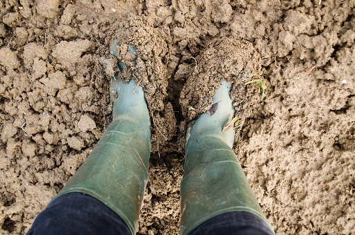 View from above on pair of boots in a mud.