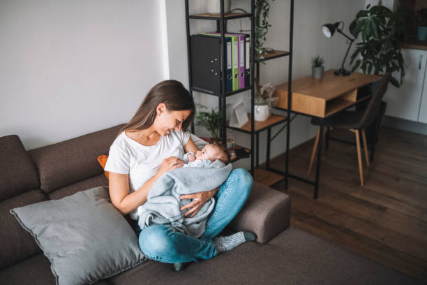 istock Young mother hugging her newborn baby while relaxing at her home. 1307404967