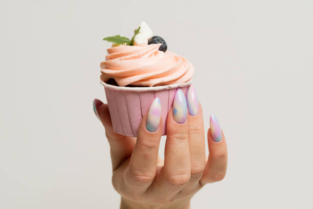 istock A female hand holds a muffin with blueberries, marshmallows and mint. Close-up 1307405109