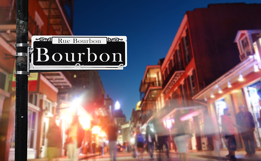 Tourists walk along Bourbon St in New Orleans French Quarter at night