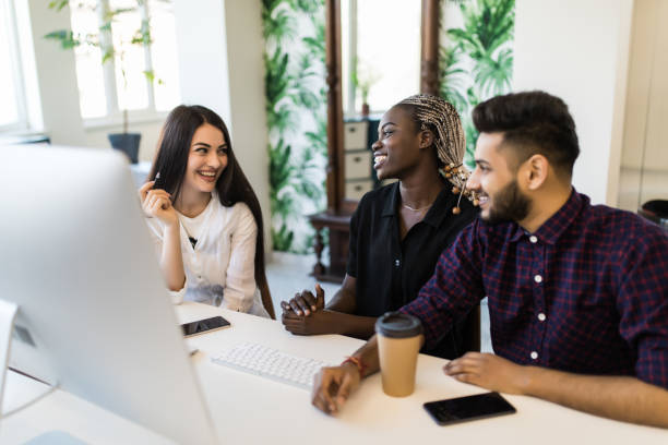 istock International confident team leader mentor use computer sitting together with diverse female colleagues at desk helping explaining to new employees corporate program giving instructions 1307406157