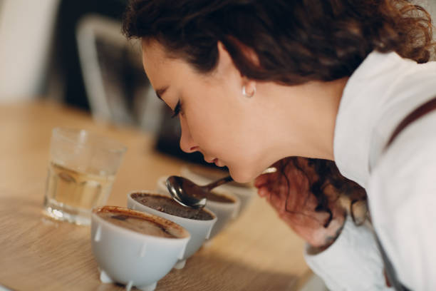カップテイスターガールテイスティングデグステーションコーヒー品質テスト コーヒーカッピング - 味見する ストックフォトと画像