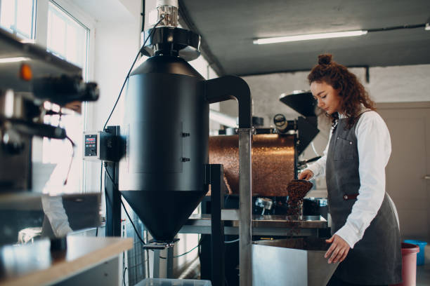 istock Woman worker at Coffee destoner machine at coffee roasting process 1307406461