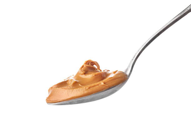 Tasty and nutritious peanut butter Spoon with creamy peanut butter isolated on white background. peanut butter stock pictures, royalty-free photos & images