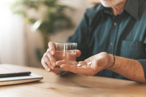 Taking medications at home. Daily dose of vitamins for the elderly in hand, headache tablets. Sedation pills Taking medications at home. Daily dose of vitamins for the elderly in hand, headache tablets. Sedation pills. painkiller stock pictures, royalty-free photos & images