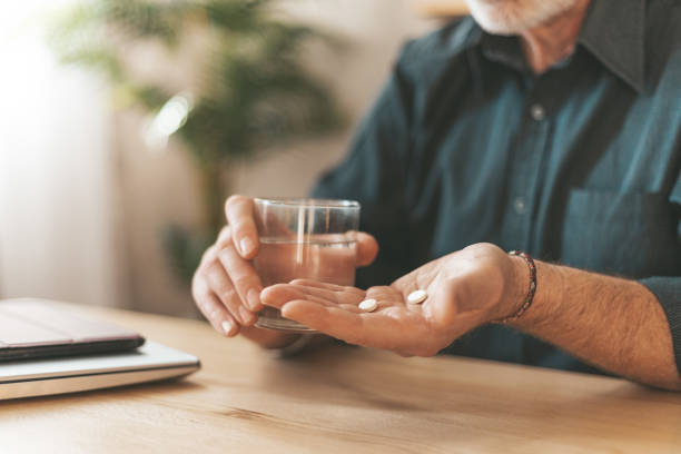 Taking medications at home. Daily dose of vitamins for the elderly in hand, headache tablets. Sedation pills Taking medications at home. Daily dose of vitamins for the elderly in hand, headache tablets. Sedation pills. antiviral drug stock pictures, royalty-free photos & images